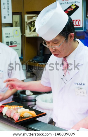 TOKYO - JANUARY 17: Japanese cook prepares sushi in a restaurant on January 17, 2013 in Tokyo. Sushi is the world famous gem of Japanese cooking.