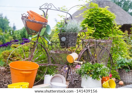 Model of an old bicycle equipped with baskets of flowers.
