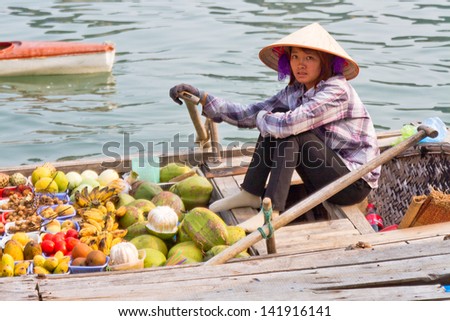 HA LONG BAY, VIETNAM - SEPTEMBER 01: Unidentified woman sells fruits from her boat on Ha Long bay, Vietnam on September 01, 2012. Floating markets are very popular  as it is only way to move around.