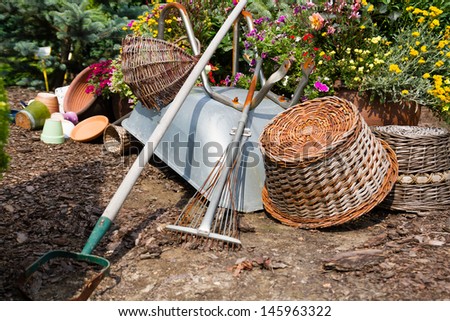 Wheelbarrow, grass mower, garden equipment, tools, preparing for planting new plants in the garden