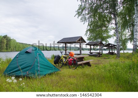 DALARNA, SWEDEN - JUNE 18: Biker established tent by the lake in Dalarna state, Sweden on June 18, 2012. Unlimited access to nature allows to put up a tent almost everywhere.