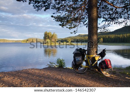 DALARNA, SWEDEN - JUNE 18: Biker established tent by the lake in Dalarna state, Sweden on June 18, 2012. Unlimited access to nature allows to put up a tent almost everywhere.