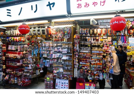 TOKYO, JAPAN - JANUARY 15: Staff helps customer to choose a souvenir in Tokyo, Japan on January 15, 2013. There are many souvenir stalls in Asakusa district as it is a popular tourist destination.