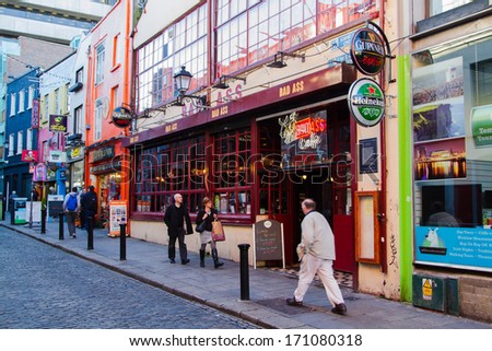 DUBLIN - NOV 11: Unidentified people walk by many bars and pubs in famous Temple Bar quarter on Nov 11, 2013 in Dublin, Ireland. Temple Bar has preserved medieval street pattern, with narrow streets.