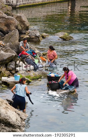LAKE ATITLAN, GUATEMALA - APRIL 23: Mayan inigenous women wash clothes and take bath on the coast of San Pedro La Laguna, Lake Atitlan, Guatemala on April 23, 2014.