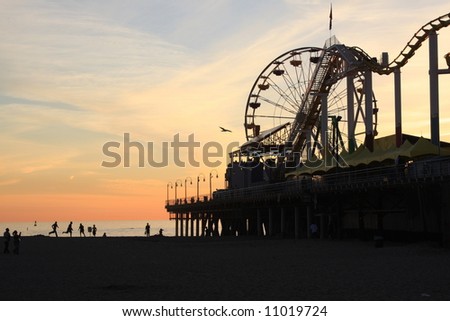Sunset and the Santa Monica Pier in Southern California with people on the beach