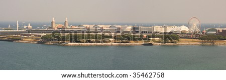 Panorama of Chicago\'s Navy Pier amusement park and rides, as well as Lake Michigan.
