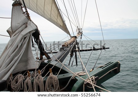 Beautiful bowsprit of a vintage wooden tall sailing ship pointed at the horizon
