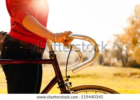Woman cycling on bicycle, sunset autumn park exercising. Take a bike for a walk, vintage old retro bike, cycling or commuting in rural country environment, ecological transportation concept
