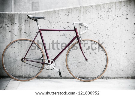 City bicycle fixed gear and concrete wall, vintage old retro bike, cycling or commuting in city urban environment, ecological transportation concept
