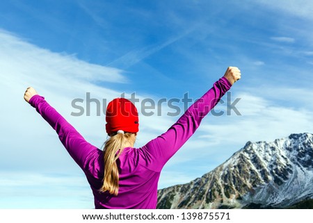 Hiking woman and success in mountains. Fitness and healthy lifestyle outdoors in winter nature