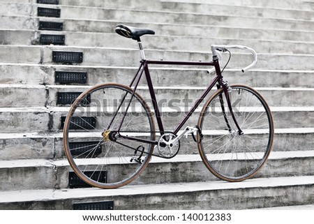 City bicycle fixed gear and concrete stairs. Vintage retro road bike over gray urban background, vintage retro style bike over grunge city urban environment, ecological transportation concept