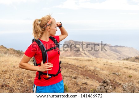 Young woman runner on trail in mountains looking at view on La Gomera island, Canary Islands. Female runner exercising outdoors in nature.