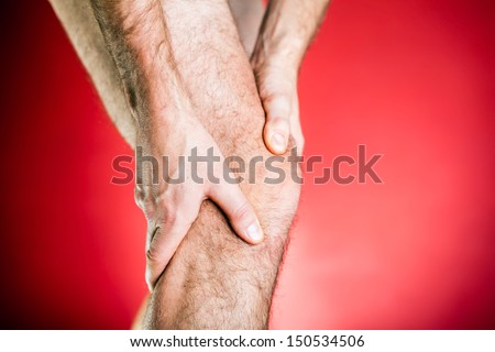 Running physical injury, leg knee pain. Runner sore body after exercising, medical examining and massage, red background