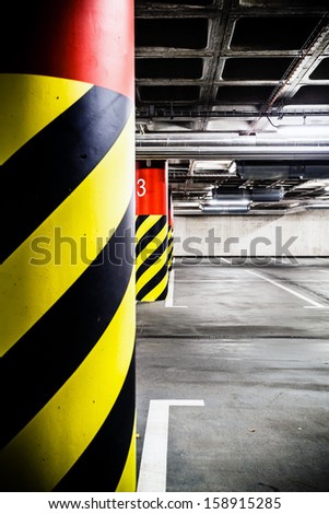 Parking garage underground modern interior. Concrete grunge industrial parking lot and column with warning sign, industrial interior.