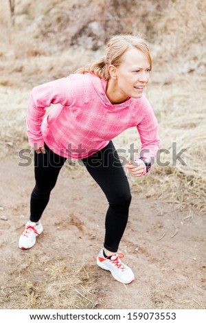 Woman running, runner exercising and stretching, autumn nature outdoors. Beauty blonde girl ready to run, sport and fitness.Motivation and inspiration sport concept outside