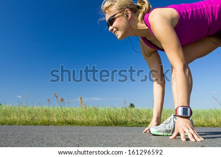Woman running on country road. Young female runner ready to run on asphalt in summer sunny nature outdoors, sport and fitness.