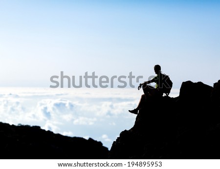 Hiking or running silhouette backpacker, man and success in mountains on mountain peak. Fitness and healthy lifestyle outdoors in summer nature on La Palma, Canary Islands