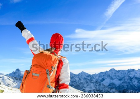 Hiking successful woman with arms outstretched, motivation inspiration in mountains. Fitness and healthy lifestyle outdoors in winter snowy beautiful nature