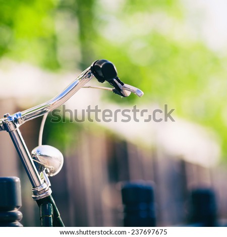 Vintage city bike colorful retro light and handlebar on street, cycling to work, commute on classic bicycle in urban environment, colorful green background