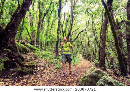 Man hiker hiking in green forest footpath. Young male looking around walking trip or get lost in green beautiful forest, La Gomera, Canary Islands Spain.