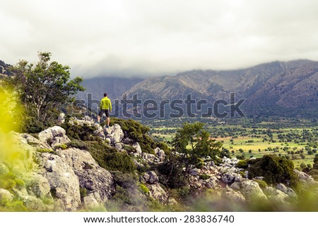 Hiking man looking at beautiful mountains inspirational landscape. Hiker trekking with backpack on rocky trail footpath. Healthy fitness lifestyle outdoors concept.