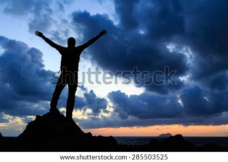Success achievement silhouette, accomplish hiking accomplishment business concept with man celebrating with arms up raised outstretched faith worship outdoors