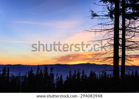 Beautiful inspirational landscape sunset in mountains. Winter hiking trail at night with colorful sunset sky.