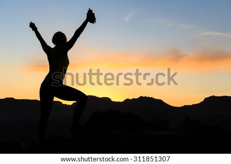 Woman hiking silhouette in mountains, sunset and ocean. Female hiker, climber or trail runner with arms outstretched on mountain top looking at beautiful night sunset inspirational landscape.