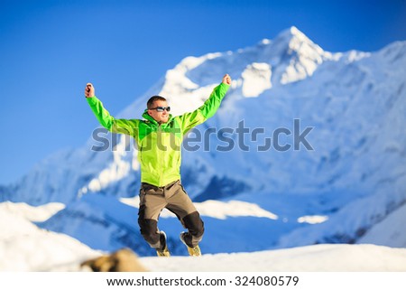 Man hiker or climber happy ecstatic achievement in winter mountains, inspiration and motivation accomplish business concept. Success climbing, beautiful inspirational landscape with mount Annapurna.