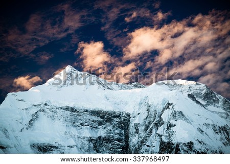 Mountain beautiful dramatic sunset inspirational landscape in Himalayas, Annapurna range, Nepal. Mountain ridge with ice and snow over clear blue sunny sky.