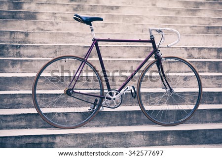 Road bicycle, fixed gear bike on city concrete street. Urban industrial cycling, bike on city stairs steps bicycle closeup, vintage old retro bike, cycling or ecology commuting. Industrial concept.