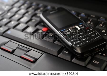 Cell phone(clean!) on laptop keyboard as a wireless technology concept.