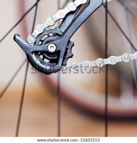 Mountain bike gear and chain. Blurred wheel and spokes in background.