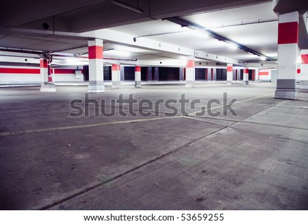 Parking garage, grunge underground interior. Neon light in bright industrial building.