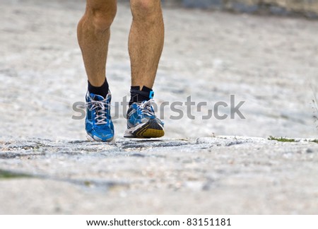 Man running in mountains, sport shoes closeup