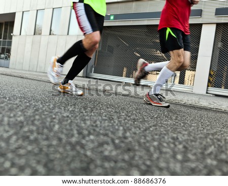 People running in marathon on city street, motion blur