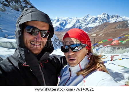 Couple hiking in Himalaya Mountains in Nepal. Man and woman doing self-portrait on Cho La pass 5420 meters. Young people traveling in Asia, trekkers on trail in wilderness.