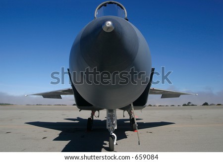 A nose on look at an F-15 on the ground with canopy open
