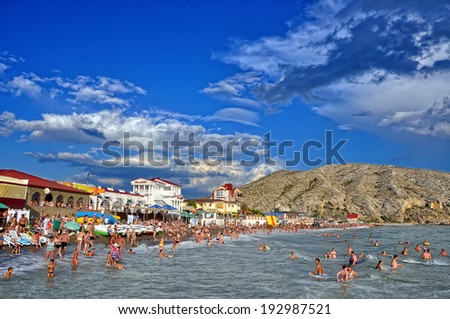 SUDAK, UKRAINE - August 21: People swim and sunbathe at the city beach of Sudak on August 21, 2012 in Sudak, Ukraine. The beach is one of the most popular holiday resorts in Crimea, Ukraine