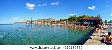 SUDAK, UKRAINE - August 28: People swim and sunbathe at the city beach of Sudak on August 28, 2012 in Sudak, Ukraine. The beach is one of the most popular holiday resorts in Crimea, Ukraine