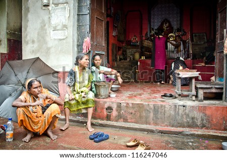 KOLKATA, INDIA - AUGUST, 28: three women begging for charity under the rain in front of a Kali temple in Kolkata, on august 28, 2012. A woman without husband is often damned to live as a beggar