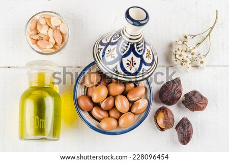 Argan Fruit on a wooden tabletop, Some fruit are without shell, other are in a Moroccan Tajine