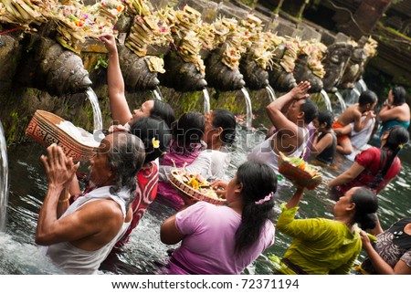 TIRTA EMPUL, INDONESIA - AUGUST 30: unidentified persons pray and bath themselves in the sacred waters of the fountains, in Tirta Empul, Bali, Indonesia, on August 30, 2009. Fountains are in a temple