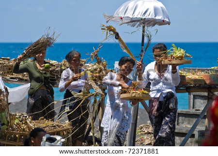 GOA LAWAH, INDONESIA - SEPTEMBER 1: Unidentified persons carry offers and say prayers to the ocean, in Goa lawah, Bali, Indonesia, on September 1, 2009. The ceremony took place  during a cremation