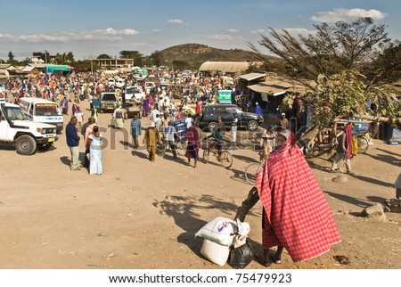 ARUSHA, TANZANIA - AUGUST 11: crowded local market near Arusha, Tanzania, on august 11, 2010. A man with the typical Masai red carpet is waiting for transport.