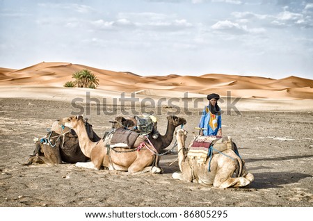 MERZOUGA, MOROCCO-AUGUST,15: Camel driver waits for tourists at the boundaries of the desert in Merzouga, Morocco, on august 15, 2011. The trip in the desert is one the main attractions in Morocco