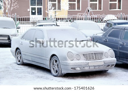 NOVYY URENGOY, RUSSIA - NOVEMBER 4, 2013: Frozen and covered by snow Mercedes-Benz W210 E-class motor car at the city street.