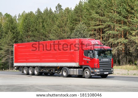 CHELYABINSK REGION, RUSSIA - MAY 24, 2008: Red Scania R380 semi-trailer truck at the interurban road.