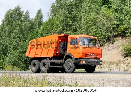 CHELYABINSK REGION, RUSSIA - AUGUST 2, 2008: New orange KAMAZ 65115 dump truck at the interurban road.